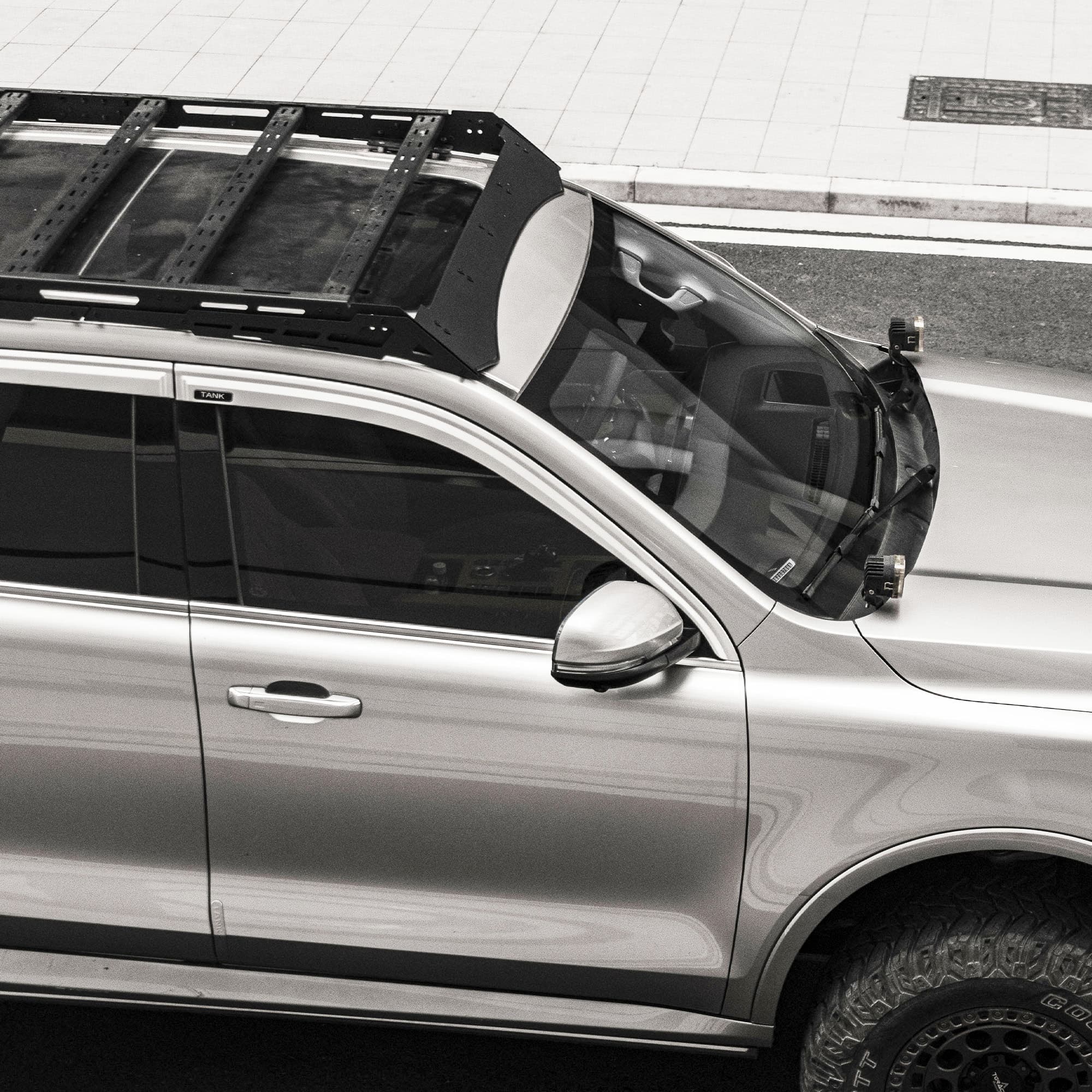 Black roof rack with slotted cross members installed on a silver Tank vehicle, viewed from above